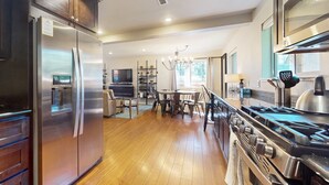 Una cocina moderna con electrodomésticos de acero inoxidable, un comedor y vistas al exterior.