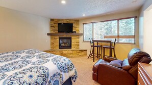 A bedroom with a bed, a fireplace, a TV, a window, and a leather sofa. - Townhome with pool, sauna, tennis, private hot tub, & foosball, sleeps 8 (Zephyr Cove)