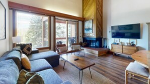 A living room with a sofa, chairs, a coffee table, a fireplace, a television, and a wooden cabinet. - Sophisticated Gold Bend Getaway | Fireplace | Free Ski Shuttle, Pool, Hot Tub (Northstar - Truckee)
