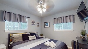 A bedroom with a bed, curtains, a ceiling fan, a TV, and a window with blinds. - Tahoe Getaway: Spacious Deck, Fireplace & Family-Friendly (South Lake Tahoe)