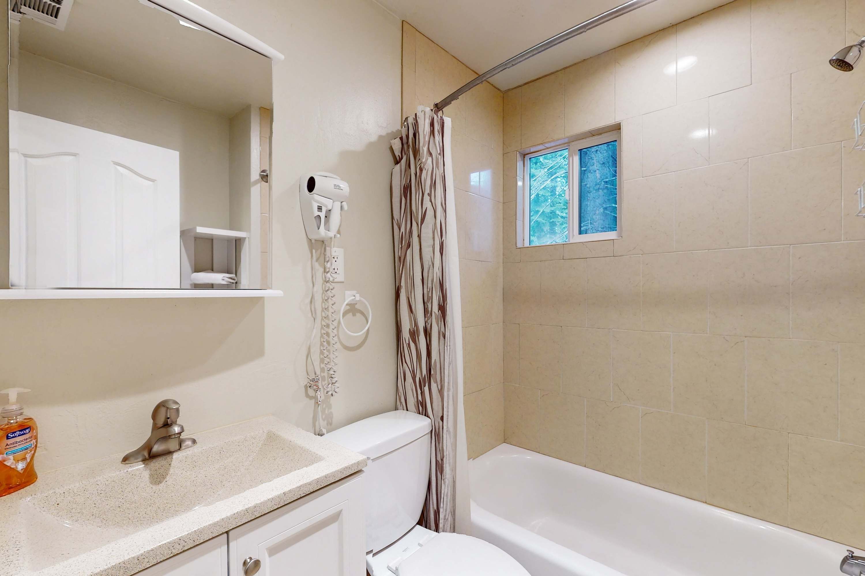 A bathroom with a toilet, sink, and shower curtain.