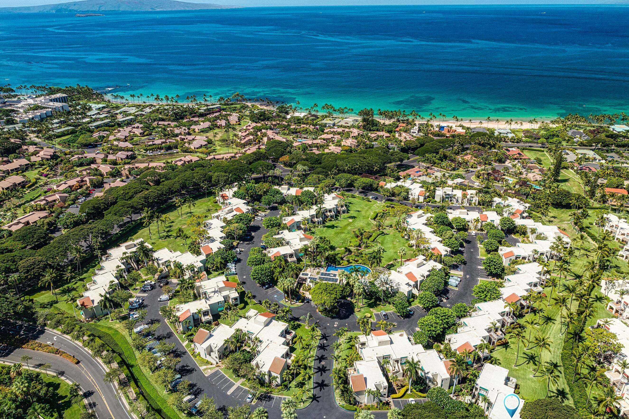 Vista aérea de una zona residencial con casas, calles y una gran masa de agua.
