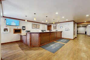 A reception area with a wooden counter, a television mounted on the wall, and a reception desk. - Find your perfect getaway to Lake Tahoe and Heavenly (South Lake Tahoe)