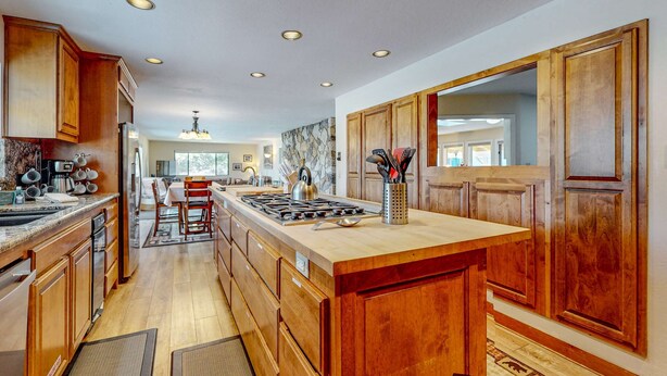 A modern kitchen with wooden cabinets, a central island, and built-in appliances. - Cozy Retreat - On Golf Course, Near Skiing, Hot Tub (South Lake Tahoe)