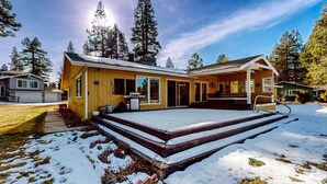 A yellow building with a covered patio and steps leading up to the entrance. - Cozy Retreat - On Golf Course, Near Skiing, Hot Tub (South Lake Tahoe)