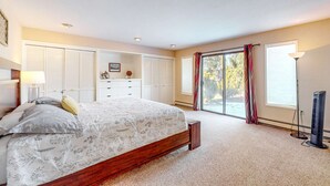A bedroom with a bed, a dresser, a desk, a chair, a lamp, and a window with curtains. - Cozy Retreat - On Golf Course, Near Skiing, Hot Tub (South Lake Tahoe)