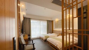 A hotel room with two beds, a desk, a chair, and a large window with curtains. - Your Lsle Inn (Zhangjiajie)