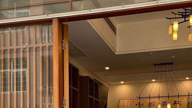 A traditional Japanese-style interior with sliding doors, a wooden counter, and a modern kitchen area. - Your Lsle Inn (Zhangjiajie)