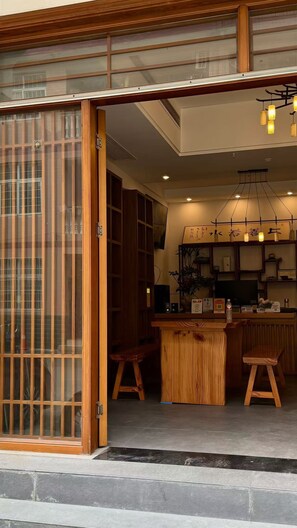 A traditional Japanese-style interior with sliding doors, a wooden counter, and a modern kitchen area.
