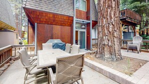 A wooden deck with a table and chairs, a large tree, and a deck chair. - Charming townhome w/ modern touches, great outdoor space, free WiFi (Incline Village)
