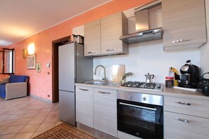 Une cuisine moderne équipée d’une cuisinière à gaz, d’un four et d’une machine à café.