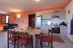 Une cuisine compacte comprenant un coin repas, un canapé et une petite table avec des chaises.
