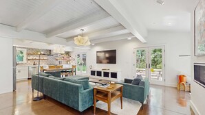 Amplia sala de estar con un sofá modular, una mesa de centro de madera y un televisor de pantalla plana grande.