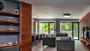A modern living room with a sofa, dining area, and a TV. - Stay With Pool in Promajna (Baska Voda)