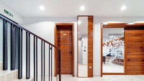 A modern interior with a staircase, wooden doors, and a reception area. - Stay With Pool in Promajna (Baska Voda)