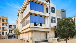 A modern hotel with a prominent 'HOTEL' sign, a flat roof, and a large window on the second floor. - Deluxe Hotel Chinar (Jaipur)