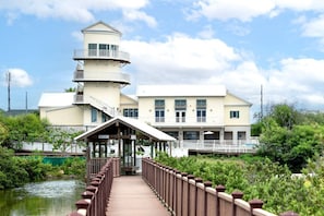 A multi-story building with a covered walkway leading to a dock. - Scallop Waterfront Cottage @ LIV `Gateway to Mars` (Port Isabel)