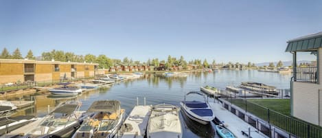 Un puerto deportivo con barcos amarrados, un edificio con balcón y cielo despejado.