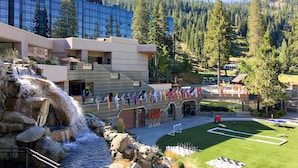 Un hotel con cascada, piscina y exhibición de banderas.