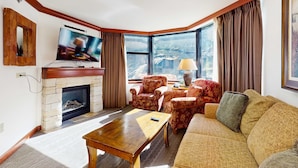 Una sala de estar con chimenea, televisión y zona de estar.