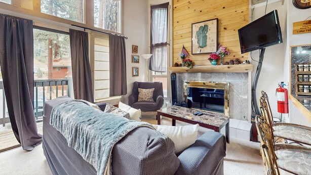 Una sala de estar acogedora con chimenea, televisor y un espacio de descanso confortable.
