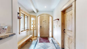 A hallway with a bench, a wooden door, and a window with a wooden frame. - Immaculate Dog-Friendly Home with Private Hot Tub, Billiards, 2 Jacuzzi Tubs (South Lake Tahoe)