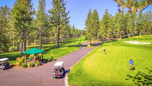 A golf course with a clubhouse, a golf cart, and a well-maintained fairway. - Dog-friendly snowbird escape with pool, hot tub & sauna access, & woodstove (Truckee)