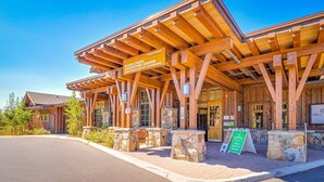 A wooden building with a sign for Alder Creek Adventure Center, featuring an entrance and stone pillars. - Dog-friendly snowbird escape with pool, hot tub & sauna access, & woodstove (Truckee)