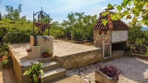 A rooftop terrace with a stone structure, steps, and potted plants. - Cozy accommodation in quiet surroundings with sea view and barbecue (Dramalj)
