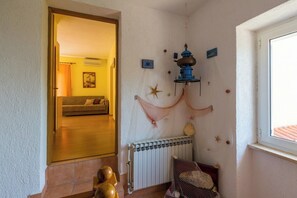 Una habitación con radiador, suelo de madera, sofá y ventana.