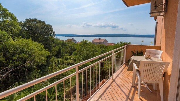 A balcony with a view of a lake and hills, a table with chairs, and a railing. - Cozy accommodation in quiet surroundings with sea view and barbecue (Dramalj)