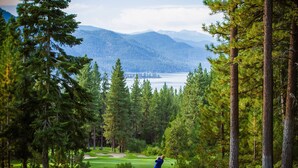 Ein Golfplatz mit Blick auf Berge und einen See.