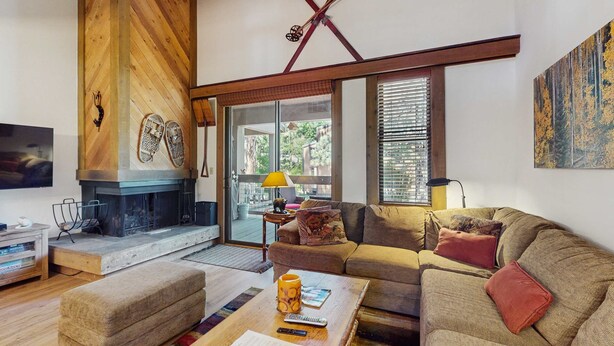 A living room with a fireplace, a sofa, a coffee table, and a television. - Vintage Ski Condo Close to Slopes with WiFi, Shared Pools & Hot Tub, & Tennis (NorthStar-Truckee)