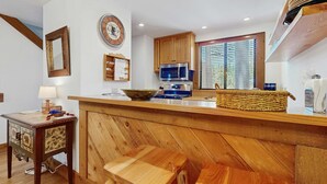 A kitchen with wooden cabinets, a microwave, a sink, and a window with blinds. - Vintage Ski Condo Close to Slopes with WiFi, Shared Pools & Hot Tub, & Tennis (NorthStar-Truckee)