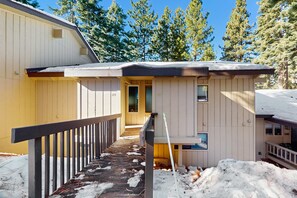 A cabin with a wooden exterior, a covered porch, and a snow-covered ground. - Spacious Condo with Fireplace, Deck, Wet Bar, Pool, Free Shuttle to Ski Resort (Incline Village)