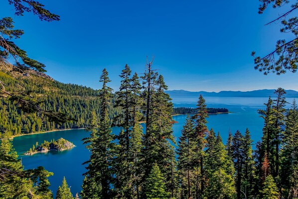 A forested landscape with a lake and mountains in the distance. - Lakefront retreat with shared pool, hot tub, & sauna - near shopping & skiing (South Lake Tahoe)