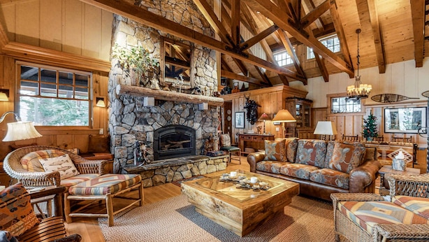 Un intérieur rustique avec une cheminée en pierre, des meubles en bois et de hauts plafonds.