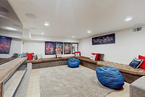 A home theater room with a large screen, comfortable seating, and a sign for 'Theater Lounge.' - Magical mountain home with movie theater, 9-person hot tub & full kitchen (Truckee)