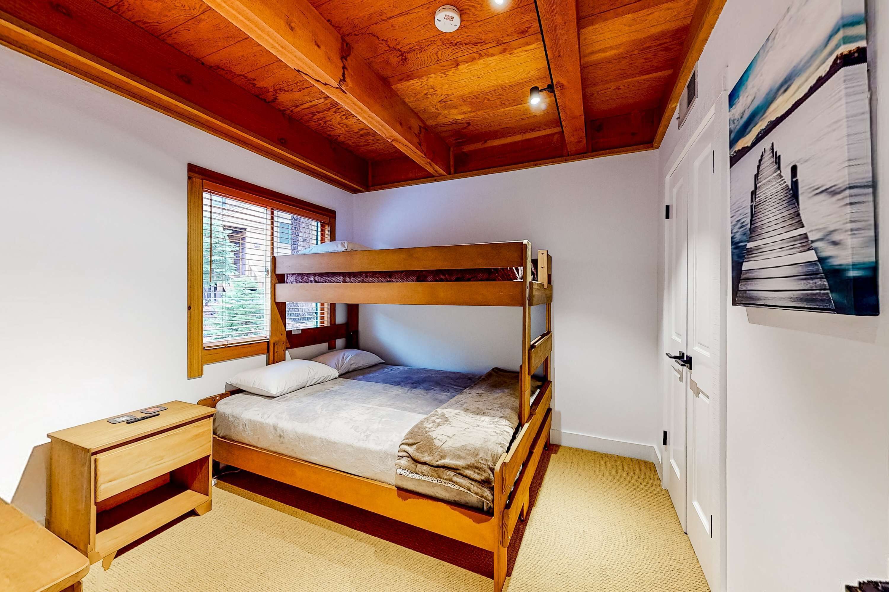 Habitación con literas, una ventana, un escritorio y una puerta.