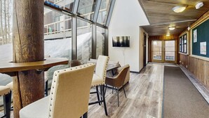 A hotel lobby with a wooden floor, a reception desk, and a seating area with chairs and tables. - Cozy studio condo with kitchenette, deck, WiFi, & nearby activities (Truckee)