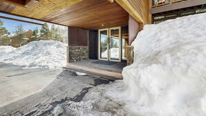 A modern building with a wooden exterior, a covered entrance, and a view of a snowy landscape. - Cozy studio condo with kitchenette, deck, WiFi, & nearby activities (Truckee)