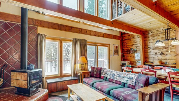 L’intérieur d’un chalet accueillant, avec un canapé, une table en bois et une cheminée.