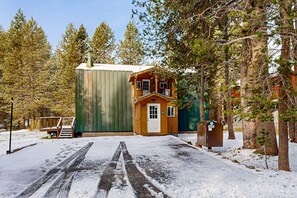 A wooden cabin with a small porch, a green exterior wall, and a mailbox labeled '5687'.