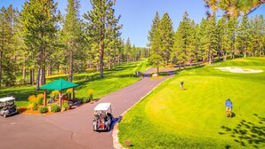 A golf course with a pavilion, a golf cart, and a sand bunker. - Woodland Retreat with Private Multi-Level Deck & Backyard Creek (Truckee)