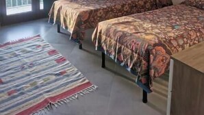 A room with two beds, a large window with curtains, a standing lamp, and a patterned rug. - Maison Angelo - Sea & mountain views, panoramic terrace in Sardinia (La Maddalena)