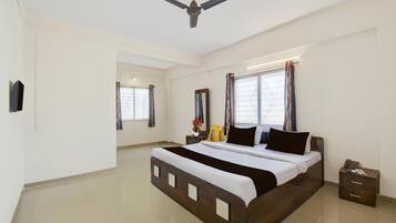 A bedroom with a bed, a nightstand, a telephone, and a ceiling fan.