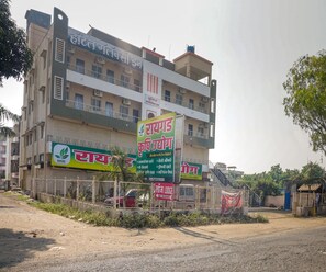 A multi-story building with a sign for a hotel and a green sign for a business.