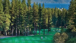 A golf course with a view of a lake and mountains. - Sleek condo with deck, BBQ, board games, and streaming (Incline Village)
