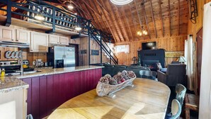 Interior rústico de una cabaña con cocina, comedor y sala de estar.