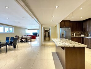 A spacious kitchen with a granite countertop, modern appliances, and a dining area with a table and chairs. - Waterfront Bright and Spacious Getaway (Innisfil)